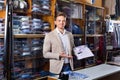 Male seller demonstrating shirts in menÃ¢â¬â¢s cloths store